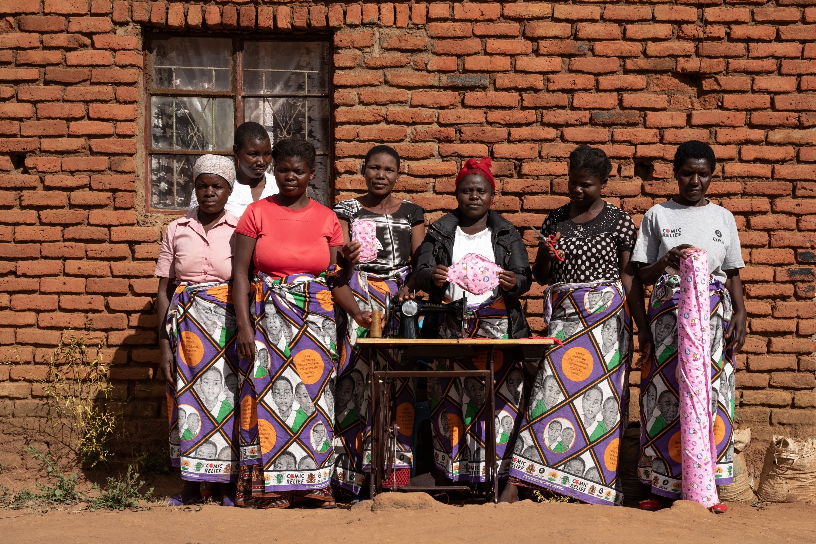 The mothers' group with a sewing machine and reusable sanitary napkin they made.